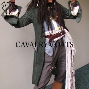 May include: A dark green long coat with the text "CAVALRY COATS" in black. The coat has buttons and long sleeves. The person is wearing a white shirt, brown belt, and grey trousers.