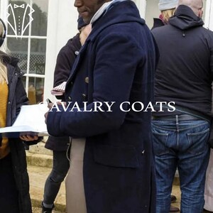 May include: A navy blue peacoat with a double breasted closure and gold buttons. The coat has a hood and is worn by a person in the image.