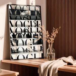 May include: A rectangular framed wall art print featuring a collage of black and white Vogue Italia magazine covers stacked horizontally. The artwork displays the bold, repeating Vogue logo in black typography against a white background.