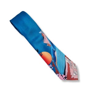 May include: A blue silk necktie with a Japanese-inspired design. The tie features a large blue whale, an orange sun, and pink cherry blossoms on a blue background. The tie is approximately 145 cm long.