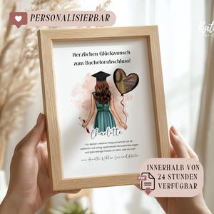Op de afbeelding: Een ingelijste print met een afstudeerthema. Het kunstwerk toont een afgestudeerde in een teal jurk en baret, met een diploma. Een hartvormige ballon met een monetair ontwerp zweeft in de buurt. Tekst bevat "Herzlichen Glückwunsch zum Bachelorabschluss!" en "Charlotte."