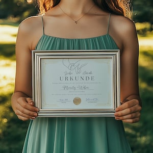 May include: A silver framed certificate with a gold border and a white background. The certificate reads "Liebe Sarah URKUNDE" and "Mandy + Niklas".