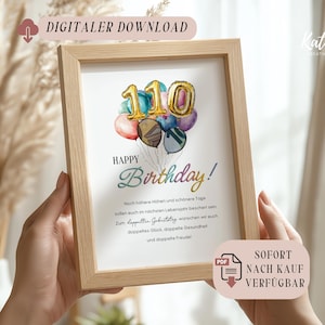 Könnte beinhalten: Gerahmter Druck mit Aquarelldesign. Der Druck zeigt eine "Happy Birthday"-Nachricht mit einer Ballon-Grafik, die die Zahl "110" anzeigt. Der Rahmen ist aus hellem Holz gefertigt.