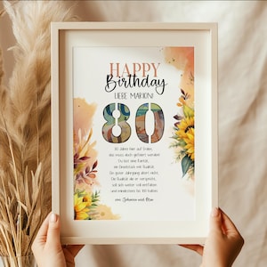 Puede incluir: Una impresión enmarcada con las palabras "HAPPY BIRTHDAY LIEBE MARION!" y el número "80" en estilo acuarela. La impresión incluye un diseño floral con girasoles y texto en alemán. El marco es de color claro.
