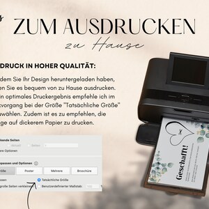 May include: A black printer with a white card being printed. The card has a green and white floral design with the text "Geschafft!" in a white heart. The printer screen shows a menu with options for printing, including "Tats&auml;chliche Gr&ouml;&szlig;e" which is selected.
