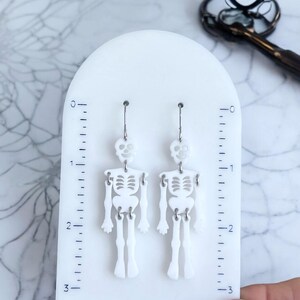 Spooky skeleton earrings, Halloween jewelry, novelty gift, wiggly joints, 2.75-inch long, 0.80-inch wide, goth style, stainless steel, gift for women, festive fall jewelry.