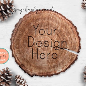 Może przedstawiać: Drewniana plastra z naturalnym wzorem słojów drewna, z tekstem "Your Design Here" w kolorze czarnym. Plastra jest otoczona białymi szyszkami sosnowymi na białym drewnianym tle.