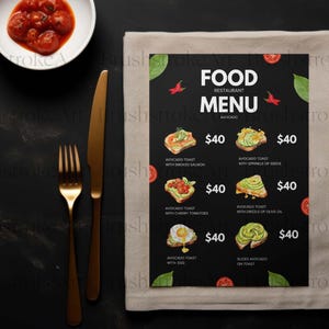 Op de afbeelding: Een restaurantmenu met avocado toast opties, met prijzen. Het menu staat op een zwarte achtergrond, met een beige servet, gouden bestek en een kleine kom met tomaten. Het menu bevat de tekst: "FOOD RESTAURANT MENU AVOCADO".