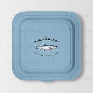 Puede incluir: Un recipiente de papel azul para llevar con un logotipo de restaurante de mariscos. El logotipo presenta una ilustraci&oacute;n de pescado y el texto "The Fish Seafood Restaurant", "Authentic Seafood" y "Straight from the Ocean".