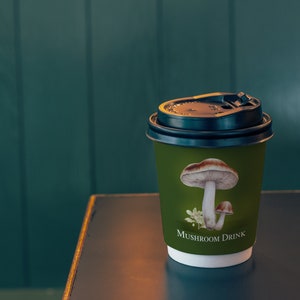 May include: A green paper cup with a black lid and a mushroom illustration. The cup says "Mushroom Drink" on the bottom.