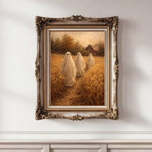 May include: A framed oil painting depicting three figures draped in white sheets walking through a golden wheat field towards a rustic wooden barn. The artwork is encased in an ornate, antique-style gold frame with intricate carved detailing.