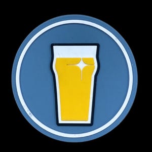 May include: A round coaster with a blue background and a white border. The coaster features a yellow beer glass graphic with a white highlight. The beer glass is outlined in black.