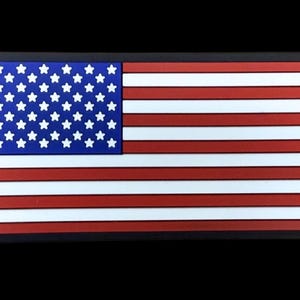 May include: Rectangular patch featuring the American flag. The flag has a blue canton with white stars and red and white stripes. The patch is framed by a black border.