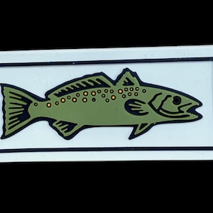 May include: A rectangular sticker featuring a stylized green fish with orange spots, outlined in black. The fish is set against a white background, framed by a black border. The sticker is likely for fishing enthusiasts.