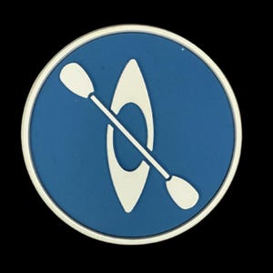 May include: A round, blue and white graphic featuring a kayak and paddle. The kayak is white and centered on a blue background. The graphic is surrounded by a silver border.