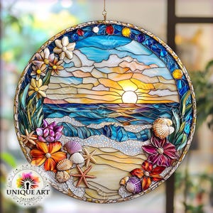 May include: A stained glass suncatcher depicting a seascape with a sunset over the ocean, waves crashing on the shore, and seashells and flowers on the beach. The suncatcher is round and has a gold frame.