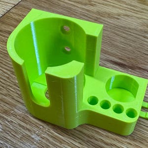 Peut inclure: Un organisateur imprim&eacute; en 3D de couleur vert vif avec un grand compartiment cylindrique et plusieurs petits compartiments circulaires.