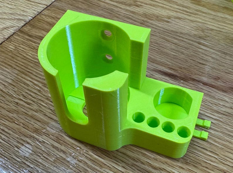 Peut inclure: Un organisateur imprim&eacute; en 3D de couleur vert vif avec un grand compartiment cylindrique et plusieurs petits compartiments circulaires.