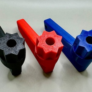 May include: Three 3D printed wrenches with star-shaped heads. The wrenches are black, red, and blue.
