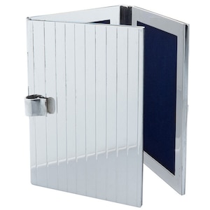 Pode incluir: Um porta-retratos de prata com uma frente articulada e um verso de veludo azul. O porta-retratos tem um design canelado decorativo.