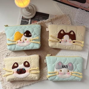 May include: Four rectangular quilted zipper pouches featuring embroidered cat faces with yarn whiskers. The pouches come in pastel mint green and cream colors, each displaying a different cat breed design with distinct ear and facial markings.