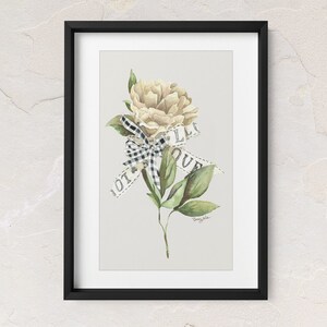 May include: A framed watercolor painting of a white flower with a black and white checkered ribbon tied around it. The ribbon has the words "I love you" written on it.