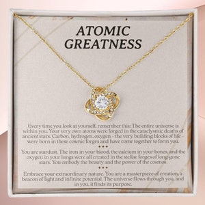 Collar de grandeza atómica, colgante de polvo de estrellas, regalo del universo, joyería radiante, cadena de luz, recuerdo cósmico, símbolo de potencial infinito, estrellas.