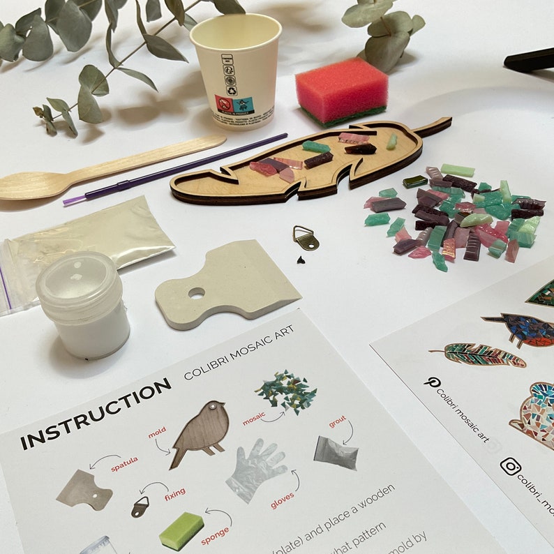 May include: A DIY mosaic art kit with a wooden feather-shaped mold, colorful glass tiles, and instructions. The kit includes a spatula, sponge, gloves, grout, and fixing glue.
