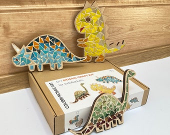 Könnte beinhalten: Ein DIY-Mosaik-Bastelset für Kinder und Erwachsene. Das Bild zeigt drei Mosaik-Dinosaurierfiguren aus Holz und bunten Mosaikfliesen. Das Set enthält eine Box mit den Worten "COLIBRI MOSAIC ART" und "DIY MOSAIC CRAFT KIT for kids&adults".
