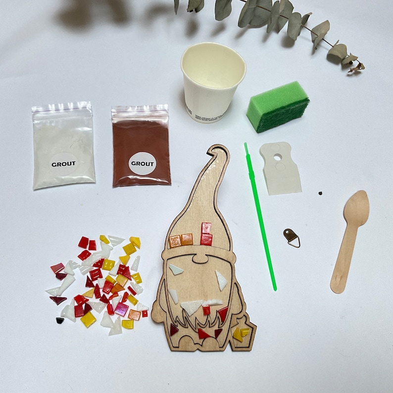 Puede incluir: Un kit de manualidades de gnomo de mosaico con varios componentes. Incluye una forma de gnomo de madera, azulejos de vidrio de colores, paquetes de lechada, una esponja, una taza, una cuchara de madera y un aplicador verde. El kit est&aacute; dise&ntilde;ado para proyectos de manualidades y mosaicos.