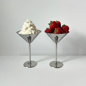 Elevate your table setting with these Beckmann and Rommerskirchen stainless steel cocktail dessert ice cream cups. Crafted in 80s Germany, their tall silver stemmed design exudes sophistication. Perfect for drinks or desserts.