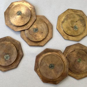 These 1960s GALLO brass coasters, made in Italy, boast a unique geometric design and time-worn patina. With a luxurious feel and iconic rooster logo, they offer a perfect blend of vintage charm and practical elegance.