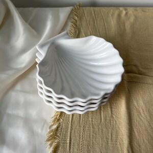 Transform your table with our Vintage Japanese Scallop Shell Ceramic Dish, a rare find from Japan. Crafted with precision and featuring a pleasant white color, this dish is ideal for baking or serving appetizers, snacks, or salads.