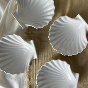 Explore culinary elegance with our Vintage Japanese Scallop Shell Ceramic Dish. Crafted in Japan, this rare find combines high quality with a soft white hue, making it ideal for baking or serving appetizers, snacks, or salads.