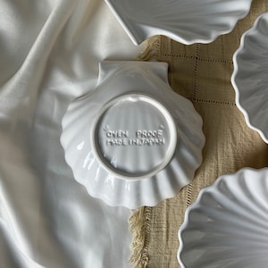 Illuminate your culinary experience with our Vintage Japanese Scallop Shell Ceramic Dish. A rare find from Japan, its high-quality craftsmanship and delightful scallop shell shape add elegance to both baking and serving occasions.