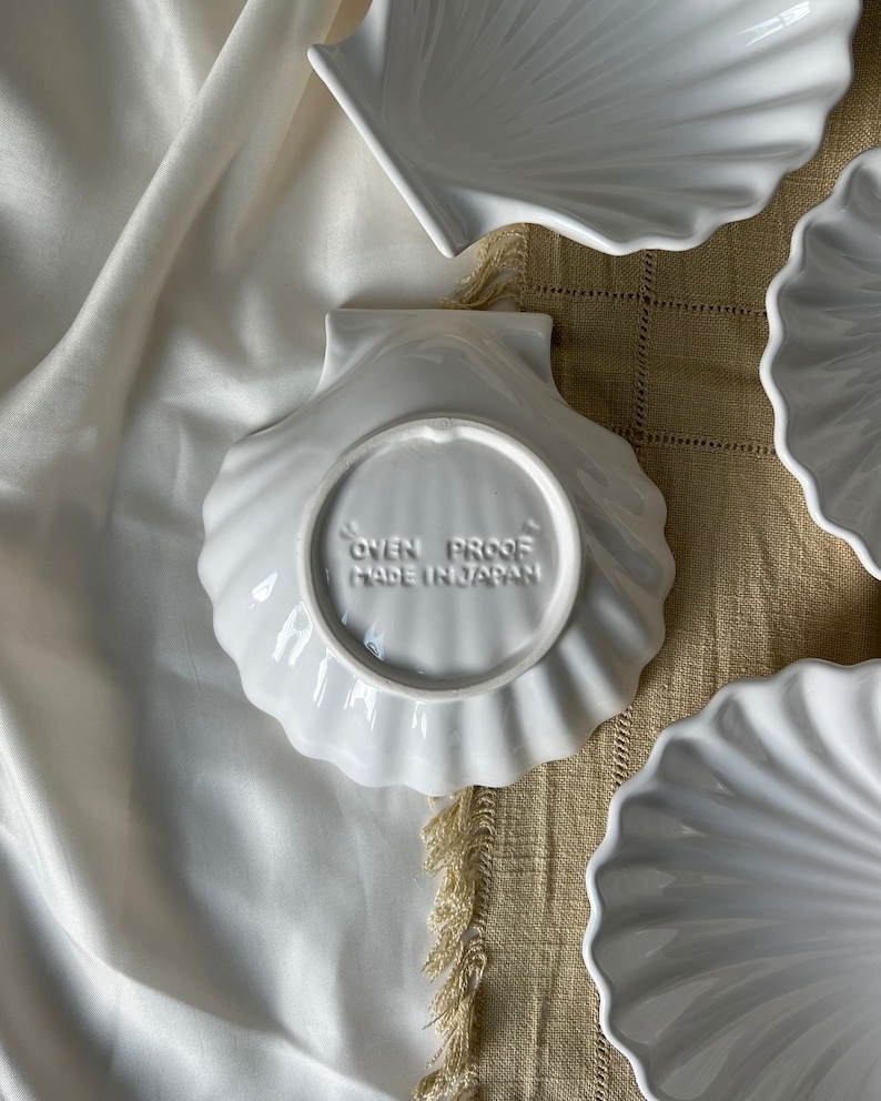 Illuminate your culinary experience with our Vintage Japanese Scallop Shell Ceramic Dish. A rare find from Japan, its high-quality craftsmanship and delightful scallop shell shape add elegance to both baking and serving occasions.