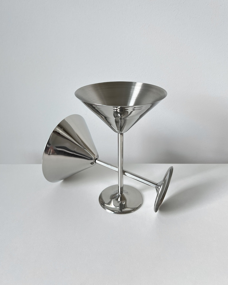 Make a statement with these Beckmann and Rommerskirchen stainless steel cocktail dessert ice cream cups. Crafted in 80s Germany, their tall silver stems and elegant design elevate any table setting. Perfect for serving drinks or desserts with flair.