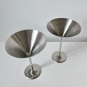 Beckmann and Rommerskirchen stainless steel cocktail dessert ice cream cups. Made in 80s Germany, their tall silver stems and sleek design add a touch of sophistication to any occasion. Serve drinks or desserts in style.