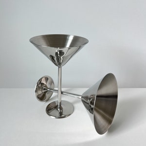 vintage Beckmann and Rommerskirchen stainless steel cocktail dessert ice cream cups. Made in 80s Germany, their tall silver stems and stylish design add a touch of elegance to any occasion. Serve drinks or desserts with timeless charm.