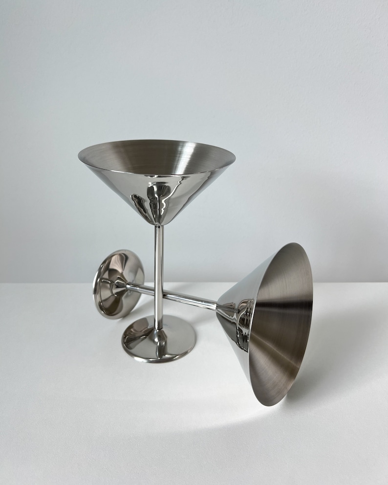 vintage Beckmann and Rommerskirchen stainless steel cocktail dessert ice cream cups. Made in 80s Germany, their tall silver stems and stylish design add a touch of elegance to any occasion. Serve drinks or desserts with timeless charm.