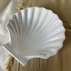 Elevate your dining experience with our Vintage Japanese Scallop Shell Ceramic Dish, a rare gem from Japan. Perfect for baking or serving, its delightful scallop shell shape and pleasant white color bring sophistication to your table.