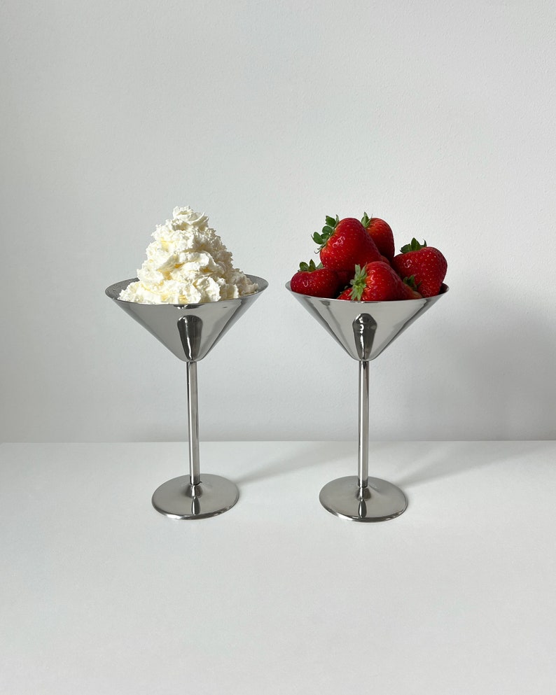 Elevate your table setting with these Beckmann and Rommerskirchen stainless steel cocktail dessert ice cream cups. Crafted in 80s Germany, their tall silver stemmed design exudes sophistication. Perfect for drinks or desserts.