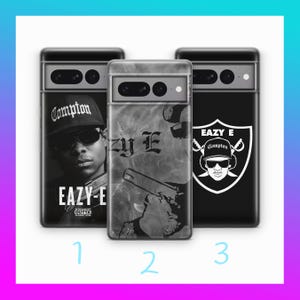 May include: Three black and white phone cases with different designs. The first case features a portrait of a rapper with the text "Compton" and "Eazy-E Straight Outta Compton". The second case features a black and white abstract design with the text "Zu E". The third case features a black and white illustration of a rapper with the text "Eazy E Compton".
