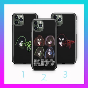 Puede incluir: Tres fundas negras para iPhone con diferentes diseños que presentan a la banda KISS. La primera funda tiene un diseño verde y negro con el logotipo de la banda y la firma de Gene Simmons. La segunda funda tiene un diseño en blanco y negro con el logotipo de la banda y una foto de los miembros de la banda. La tercera funda tiene un diseño negro y rojo con el logotipo de la banda y la firma de Paul Stanley.