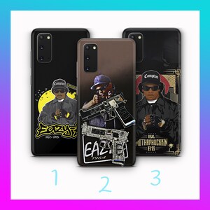 May include: Three phone cases with images of Eazy-E. The first case is black with a yellow and white graphic. The second case is brown with a picture of Eazy-E holding a gun. The third case is black with a gold and white graphic.