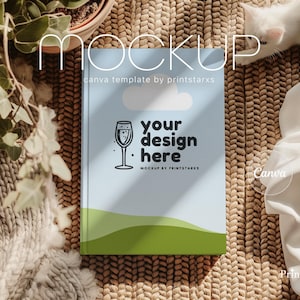 Op de afbeelding: Een blauwe en groene mockup-sjabloon voor een notitieboek met de tekst "your design here" en "Canva mockup by printstarxs".