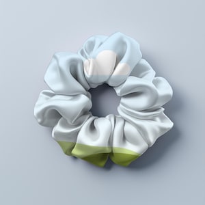 May include: A light blue and green patterned scrunchie with a white cloud design.