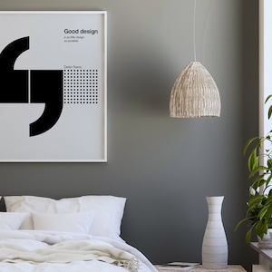 May include: A framed black and white poster with a quote by Dieter Rams: "Good design is as little design as possible."