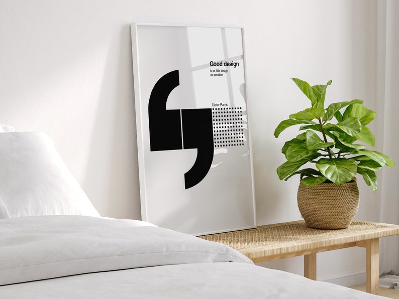 May include: A black and white minimalist poster with a quote about good design. The quote reads "Good design is as little design as possible." The poster is framed in a white frame and is hanging on a white wall.