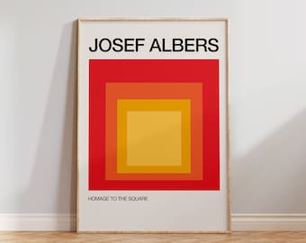 May include: A framed print of a geometric abstract art piece by Josef Albers titled "Homage to the Square". The artwork features a series of concentric squares in shades of red, orange, and yellow.